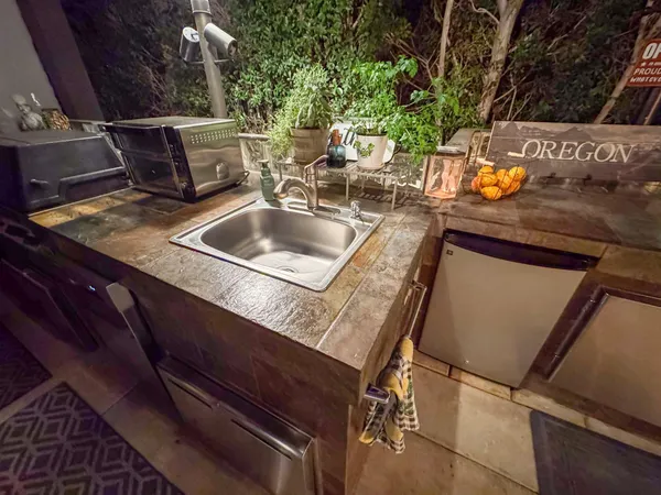 a living room with patio furniture and a potted plant