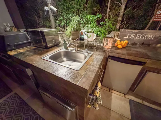 a living room with patio furniture and a potted plant