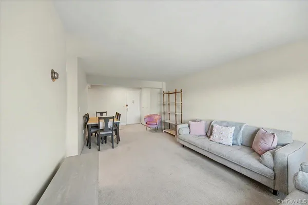 a living room with furniture and a dining table with a large window