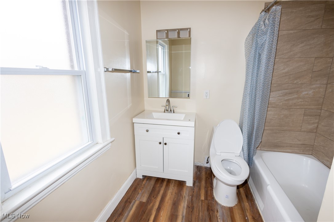 1000 Quilliams Road Cleveland, OH 44121 - Photo 19 of 34 Full bathroom featuring hardwood / wood-style flooring, vanity, toilet, and shower / tub combo