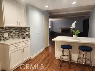 a kitchen with granite countertop a sink cabinets and wooden floor
