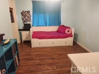 a view of a bedroom with wooden floor