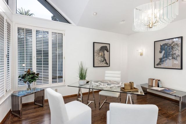 a living room with couches and painting on the wall with wooden floor