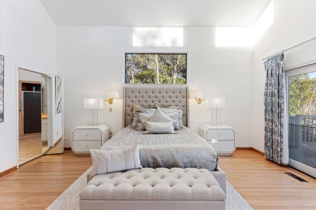 a bedroom with a large bed and a large window with outer view