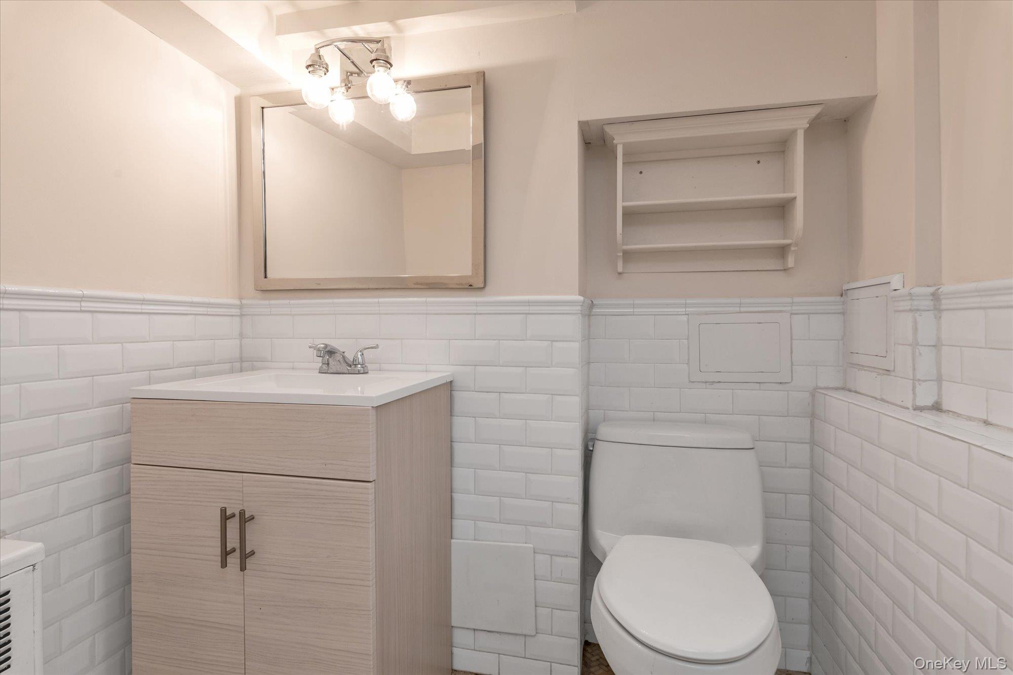 26 Cheshire Road Inwood, NY 11096 - Photo 16 of 22 a bathroom with a toilet sink vanity and mirror