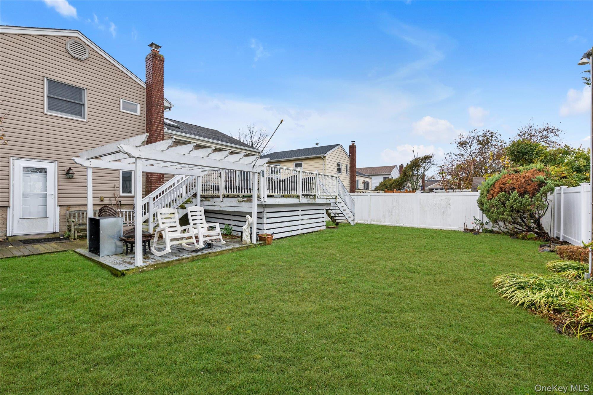 26 Cheshire Road Inwood, NY 11096 - Photo 18 of 22 Fenced backyard featuring a deck