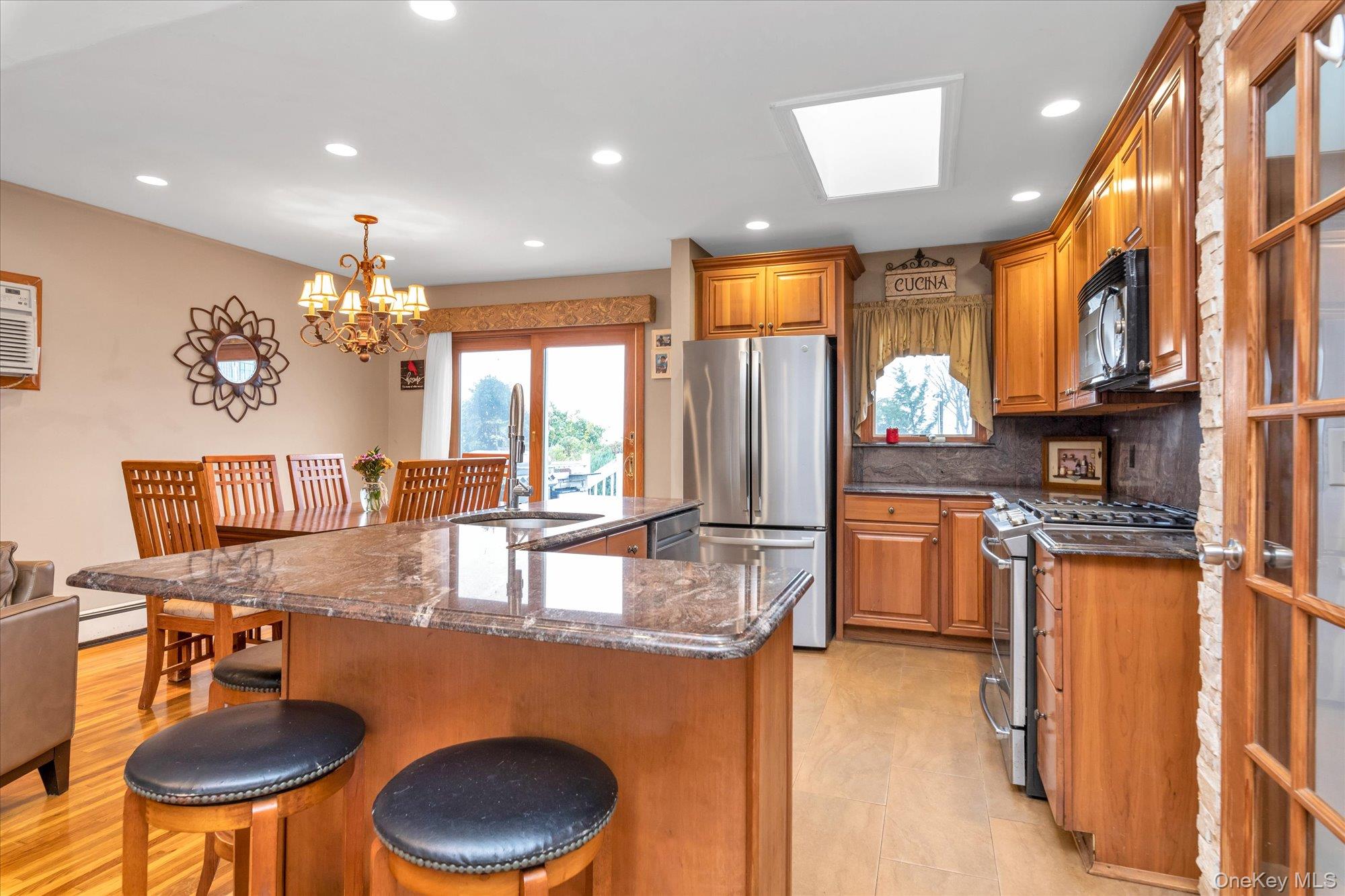 26 Cheshire Road Inwood, NY 11096 - Photo 7 of 22 a kitchen with stainless steel appliances granite countertop a sink a stove and a refrigerator