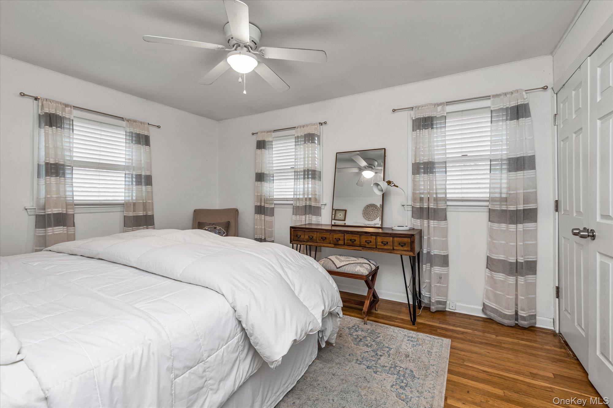 26 Cheshire Road Inwood, NY 11096 - Photo 9 of 22 Bedroom with wood finished floors, a ceiling fan, and multiple windows