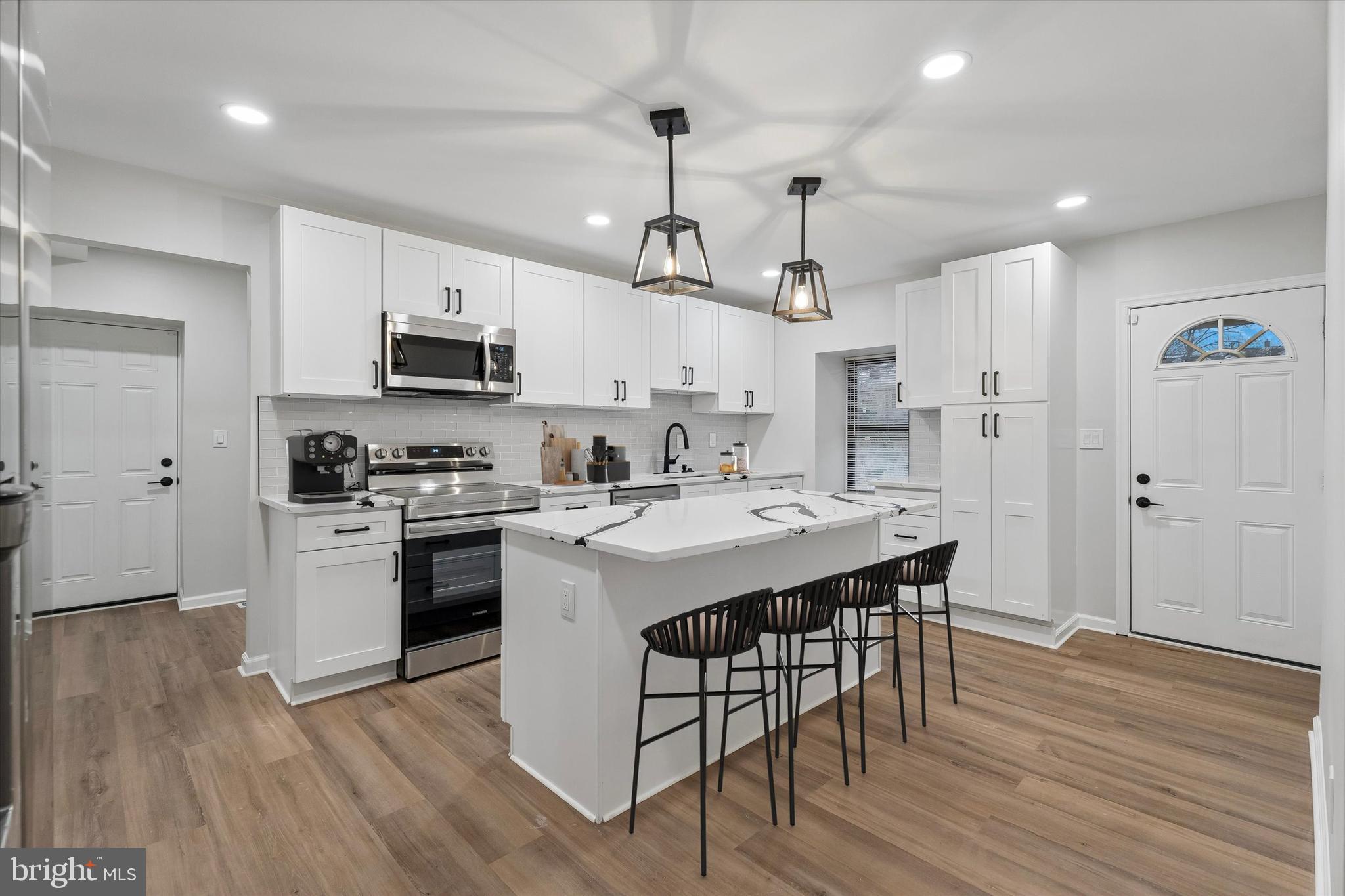 4359 Fleming Street Philadelphia, PA 19128 - Photo 6 of 43 a kitchen with white cabinets stainless steel appliances and wooden floor