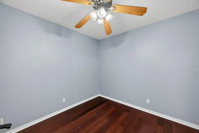 a view of room with wooden floor and ceiling fan