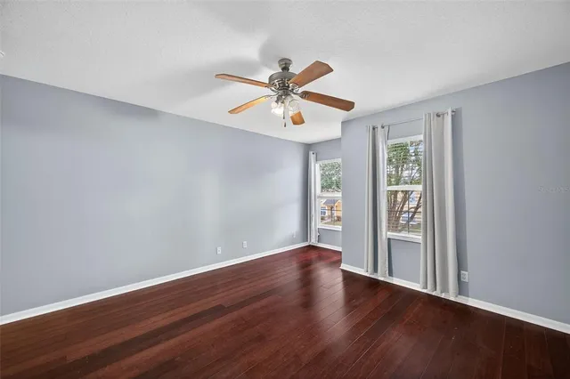 a view of a room with wooden floor and a ceiling fan