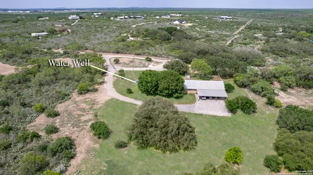 an aerial view of residential houses with outdoor space and trees