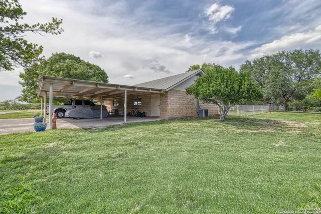 a view of a house with backyard and a garden