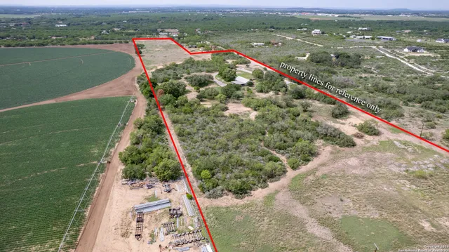 an aerial view of residential house with outdoor space and trees all around