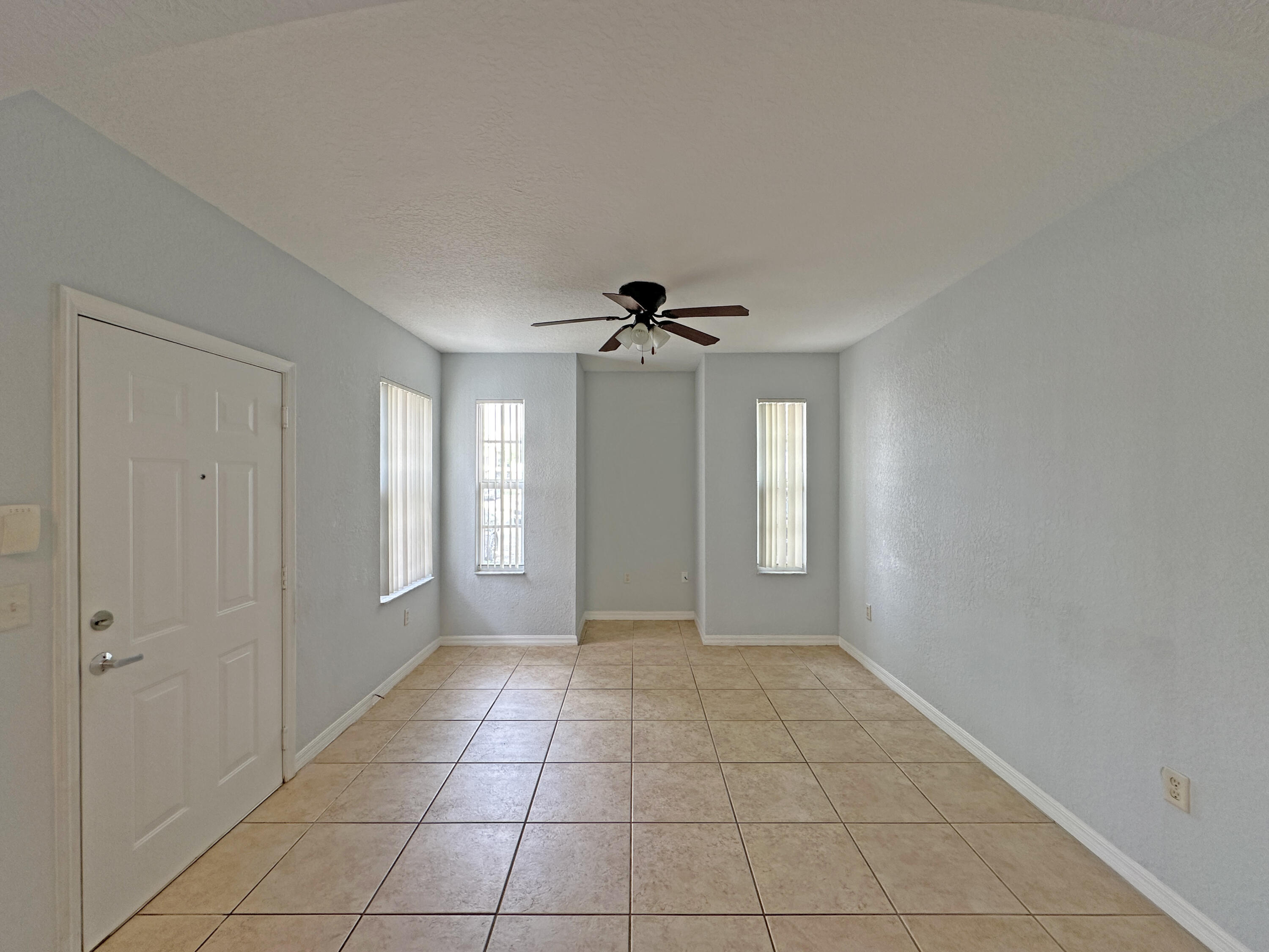 144 Southwest Peacock Boulevard, Unit 101 Port St. Lucie, FL 34986 - Photo 9 of 52 a view of an empty room with window and chandelier fan