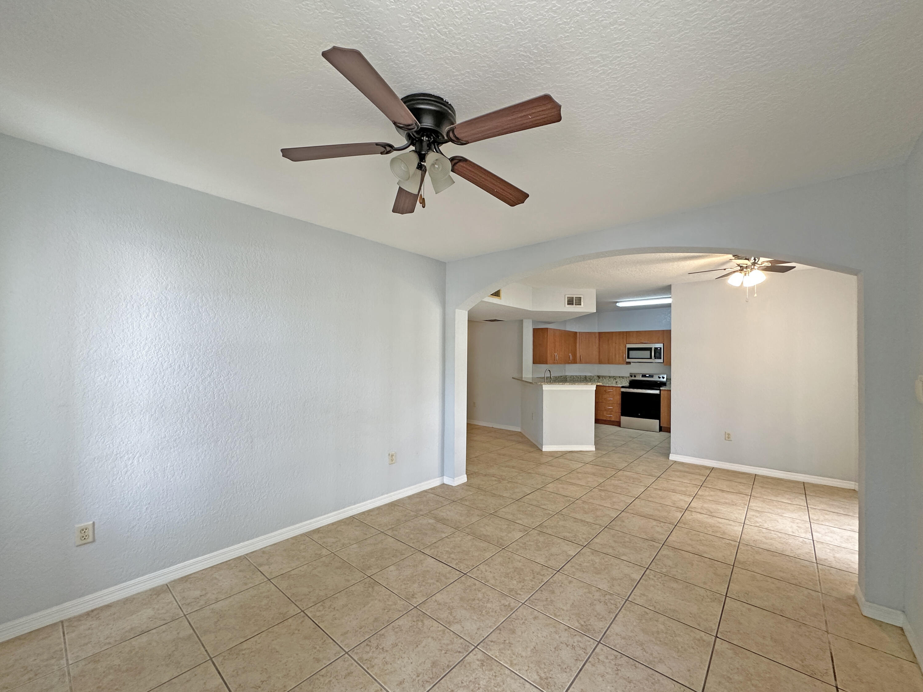 144 Southwest Peacock Boulevard, Unit 101 Port St. Lucie, FL 34986 - Photo 10 of 52 a view of a livingroom with a ceiling fan