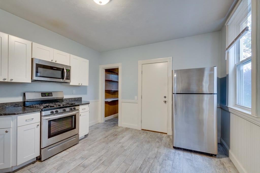 37 Taft Street Boston, MA 02125 - Photo 14 of 15 a kitchen with a refrigerator stove and wooden cabinets