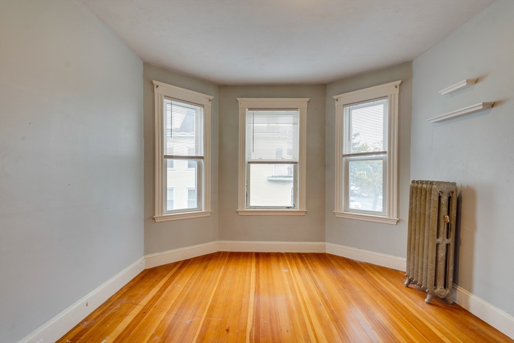 37 Taft Street Boston, MA 02125 - Photo 6 of 15 an empty room with wooden floor and windows