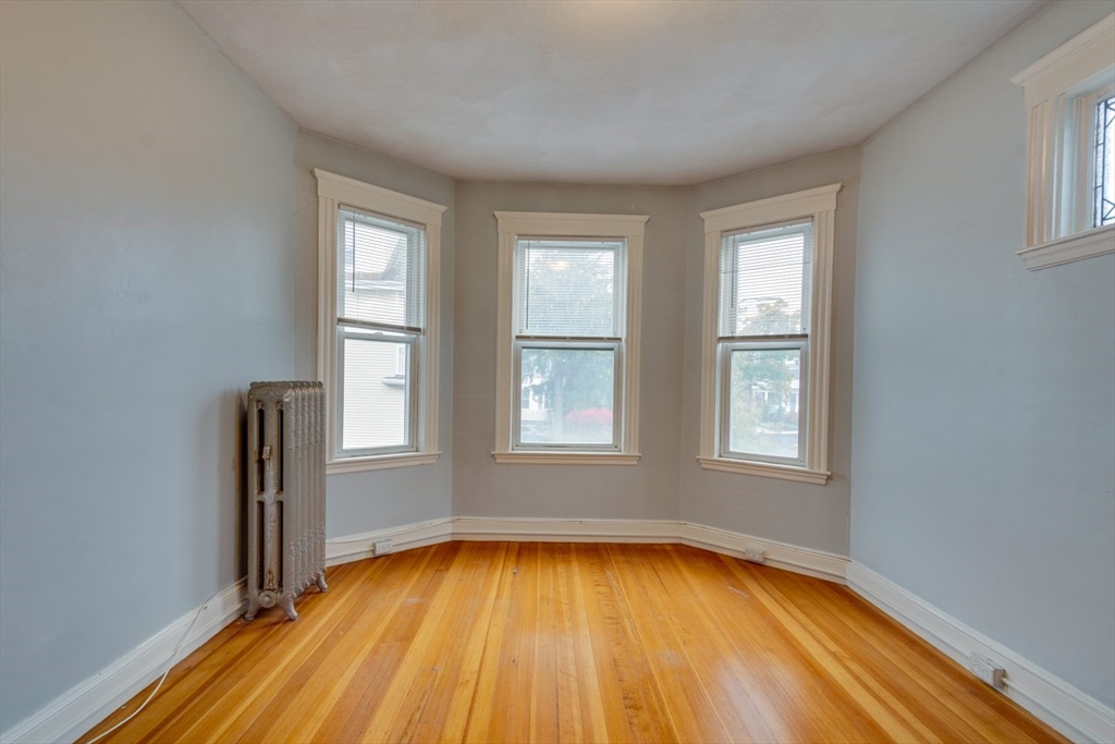 37 Taft Street Boston, MA 02125 - Photo 7 of 15 an empty room with wooden floor and windows