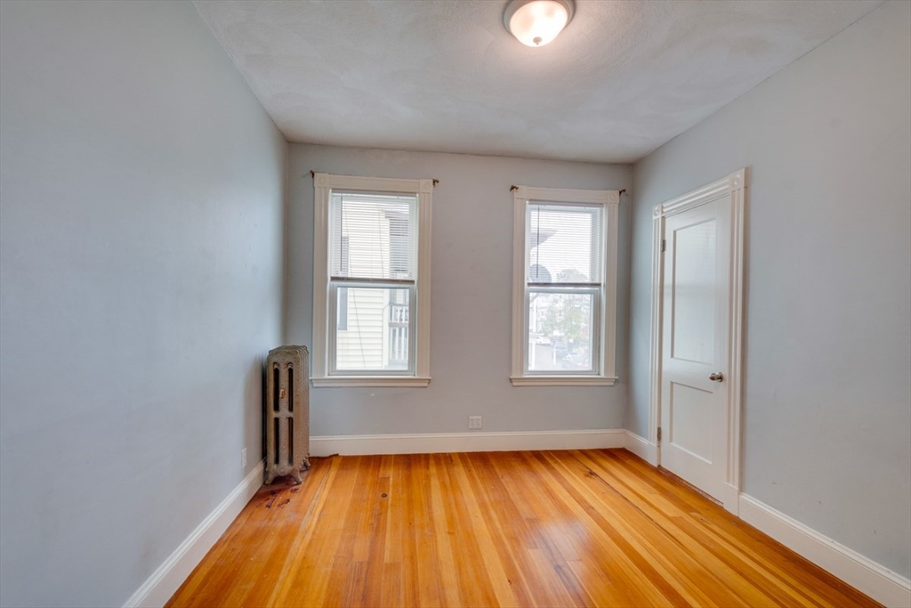 37 Taft Street Boston, MA 02125 - Photo 9 of 15 an empty room with wooden floor and windows