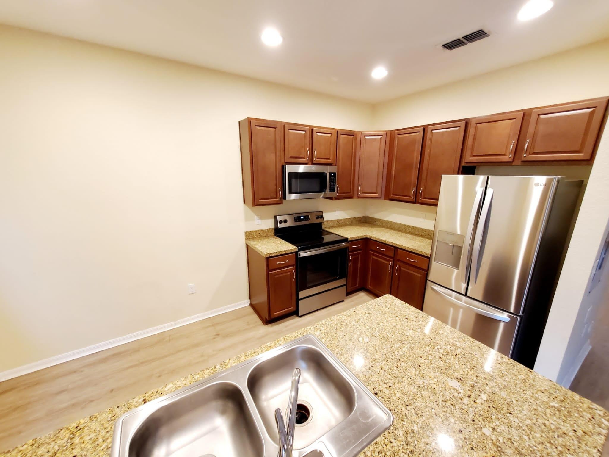 2851 Prospect Road Tamarac, FL 33309 - Photo 12 of 21 a kitchen with granite countertop a refrigerator and a sink