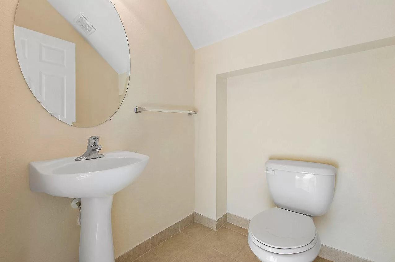 2851 Prospect Road Tamarac, FL 33309 - Photo 17 of 21 a bathroom with a toilet sink and mirror