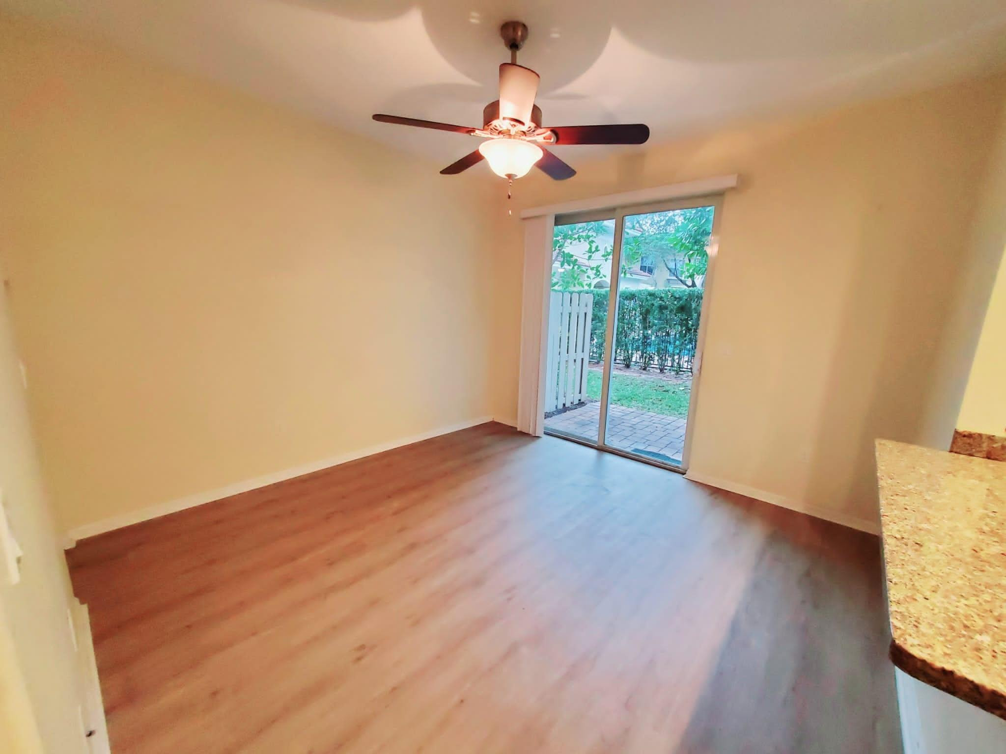 2851 Prospect Road Tamarac, FL 33309 - Photo 3 of 21 a view of an empty room with wooden floor and a window