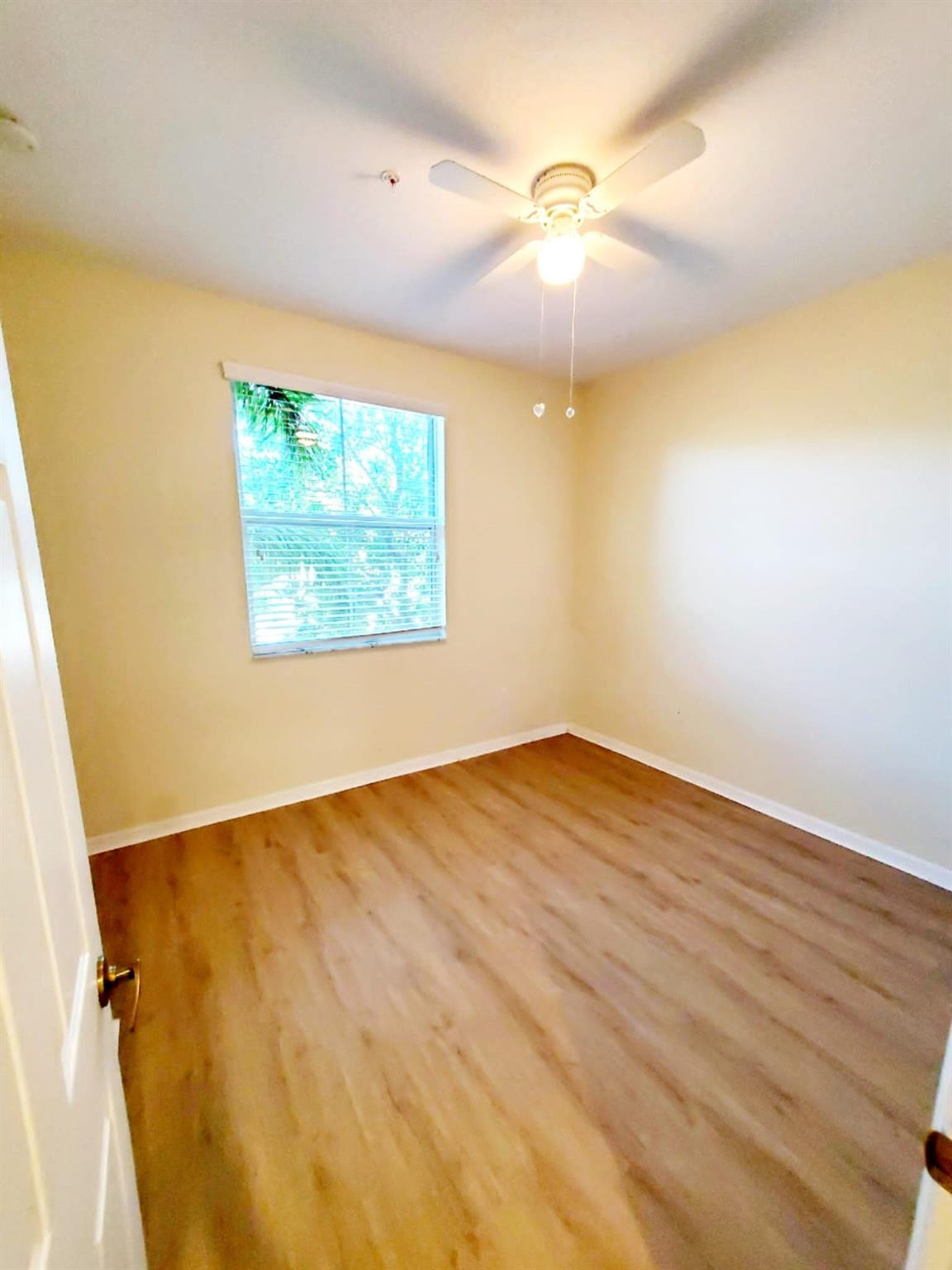2851 Prospect Road Tamarac, FL 33309 - Photo 8 of 21 an empty room with wooden floor and windows