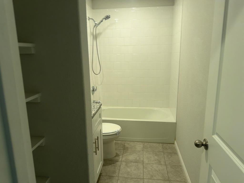 721 Durango Lane Cleburne, TX 76033 - Photo 19 of 25 a bathroom with a granite countertop toilet a sink and shower