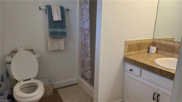 a bathroom with a granite countertop toilet and a sink