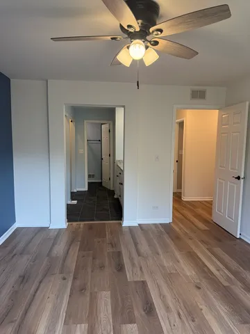 a view of a room with wooden floor and ceiling fan