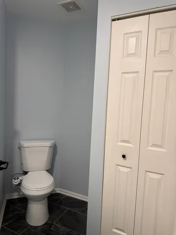 a white toilet sitting next to a shower