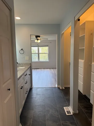 a bathroom with a granite countertop sink a mirror and a shower
