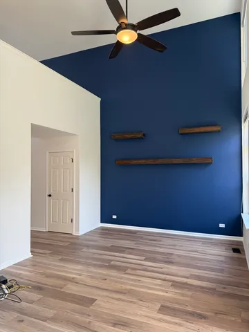 a view of empty room with window and wooden floor