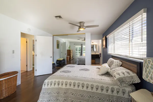 a large bedroom with a large bed and wooden floor