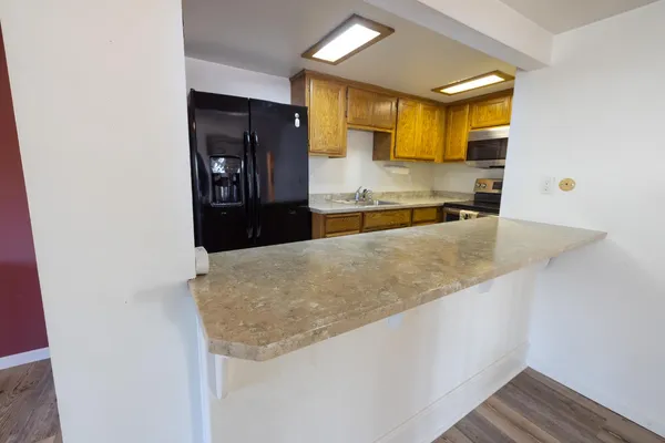 a kitchen with stainless steel appliances granite countertop a refrigerator and a stove