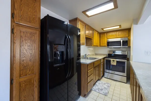 a kitchen with stainless steel appliances a stove microwave and sink