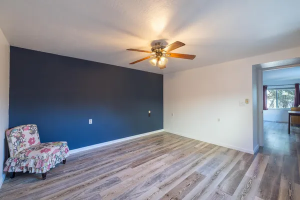 a room with lots of white furniture and a rug
