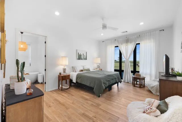 a spacious bedroom with a bed and wooden floor