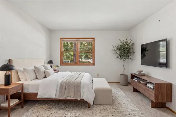a bedroom with a bed and a flat screen tv