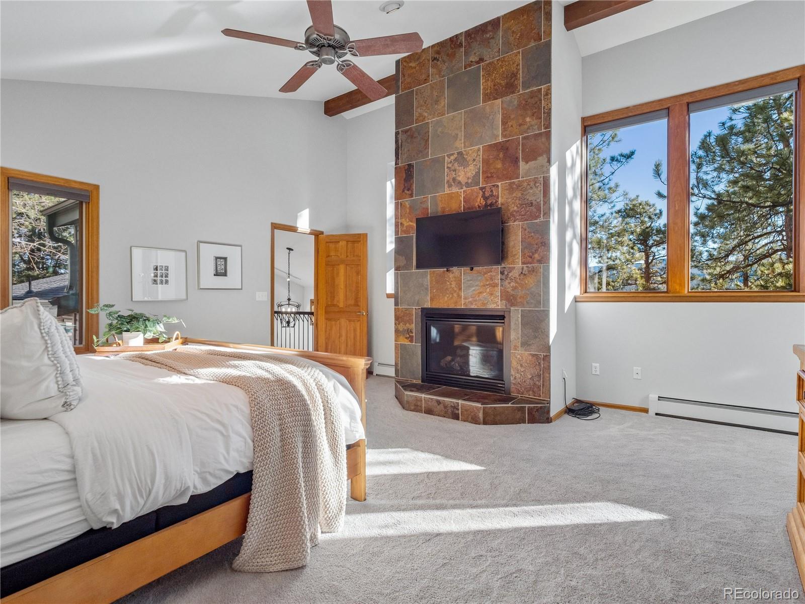 67 Oak Way Evergreen, CO 80439 - Photo 27 of 44 a bedroom with a bed and a fireplace