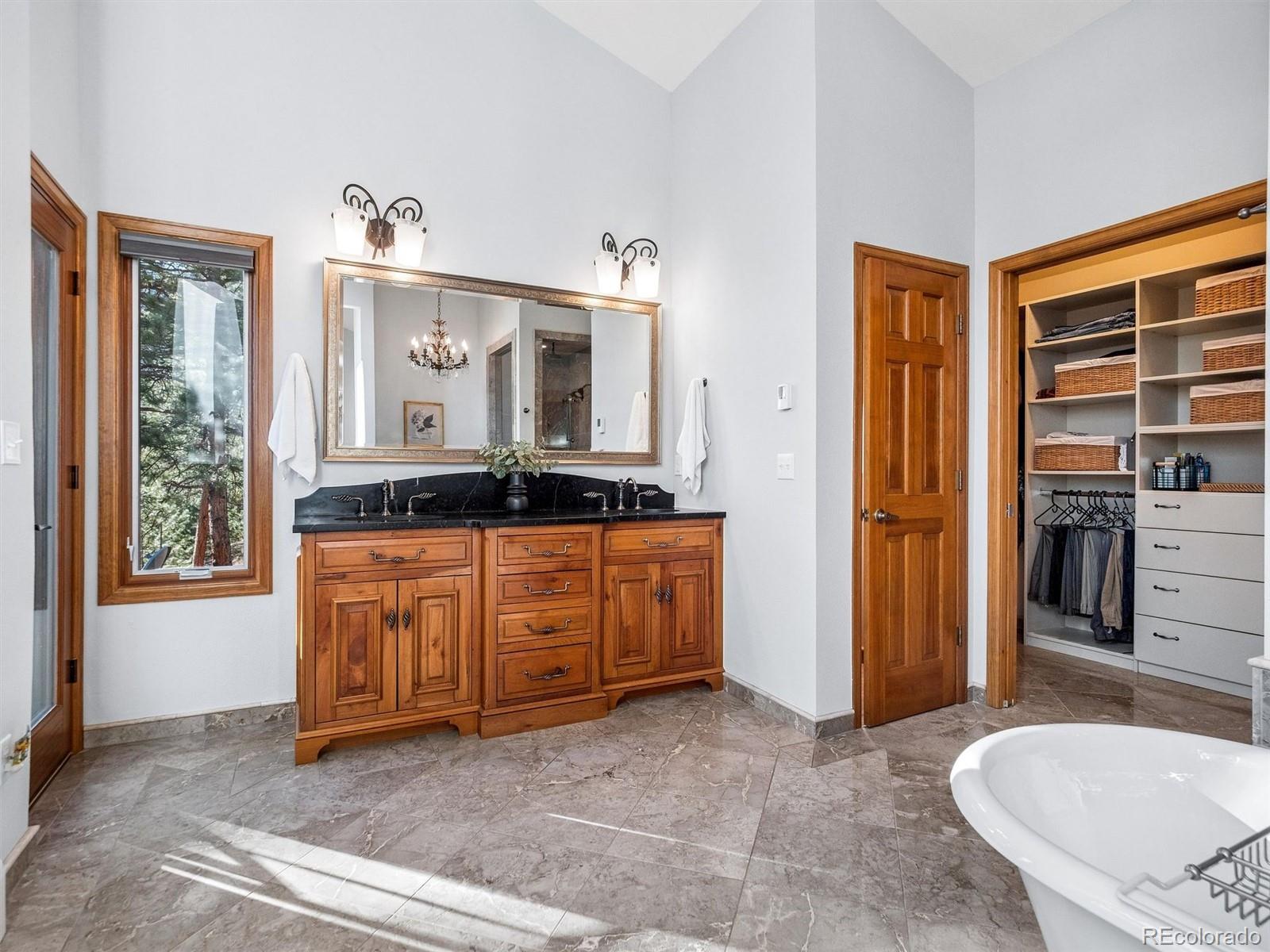 67 Oak Way Evergreen, CO 80439 - Photo 28 of 44 a spacious bedroom with a bed and a dresser