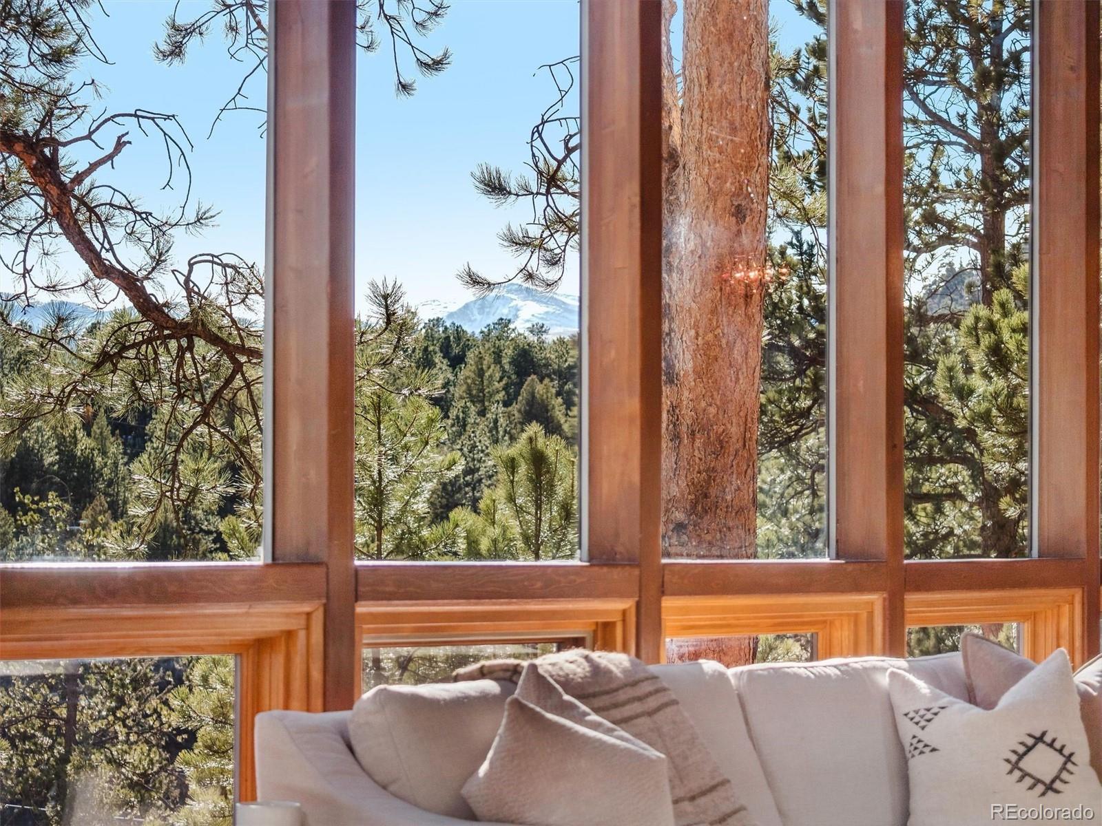 67 Oak Way Evergreen, CO 80439 - Photo 3 of 44 a view of a balcony with furniture and a potted plant