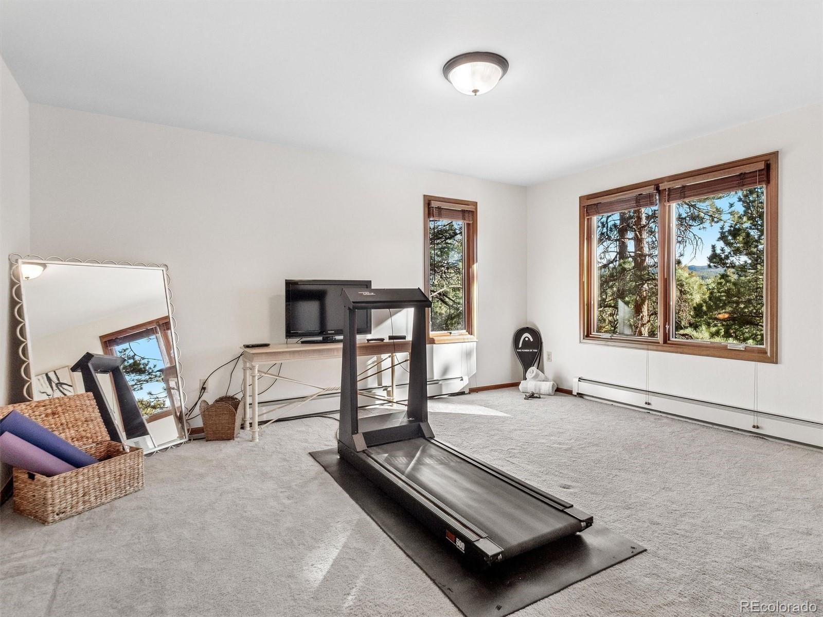 67 Oak Way Evergreen, CO 80439 - Photo 36 of 44 a living room with furniture a flat screen tv and a window
