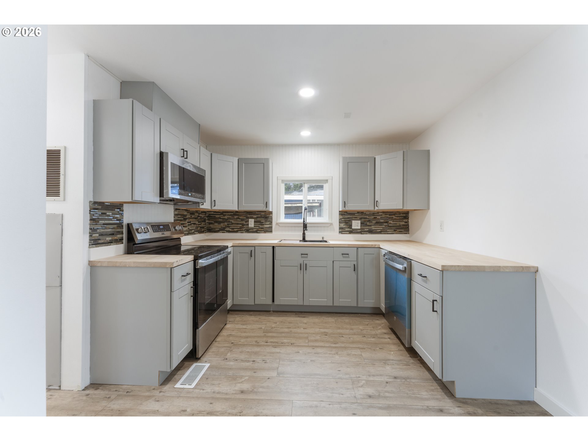 4424 Southeast Roethe Road, Unit 3 Milwaukie, OR 97267 - Photo 13 of 30 a kitchen with a refrigerator stove a sink and a microwave