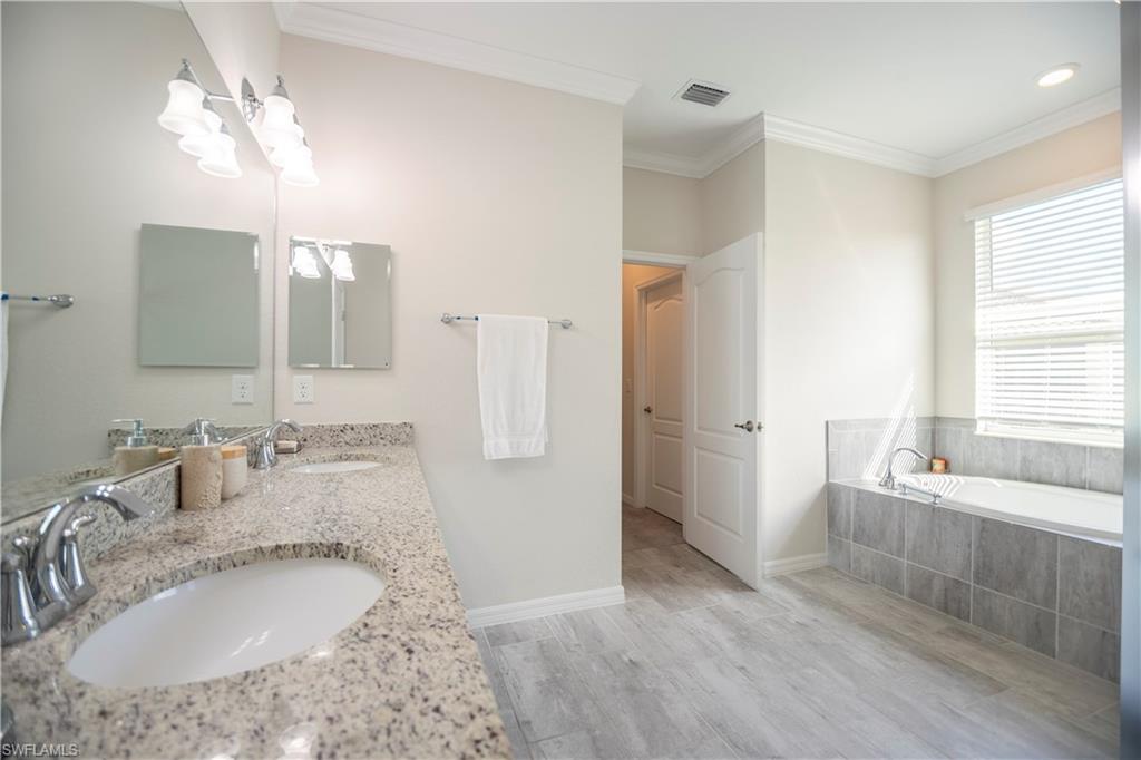 2075 Parson Street Naples, FL 34120 - Photo 12 of 15 a bathroom with a granite countertop sink a large mirror and shower