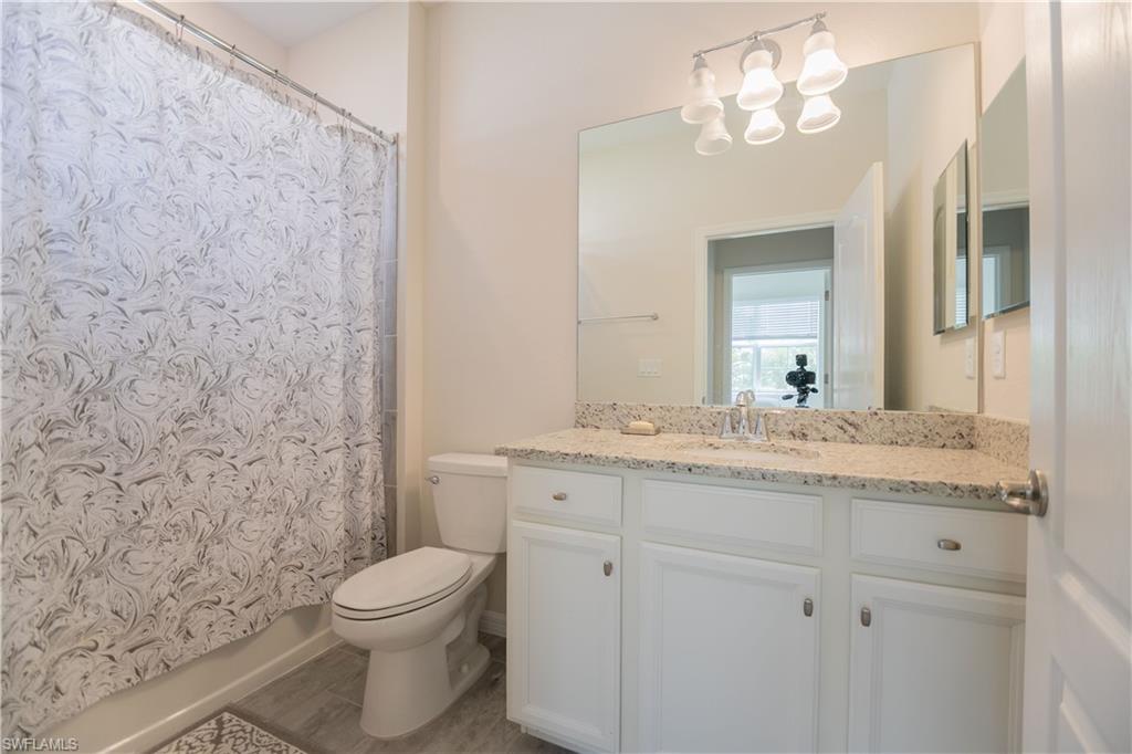 2075 Parson Street Naples, FL 34120 - Photo 10 of 15 a bathroom with a granite countertop toilet a sink and a mirror