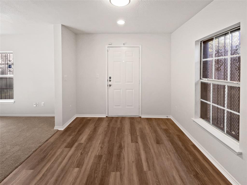 4346 Hamilton Avenue Dallas, TX 75210 - Photo 12 of 16 a view of an empty room with wooden floor and a window