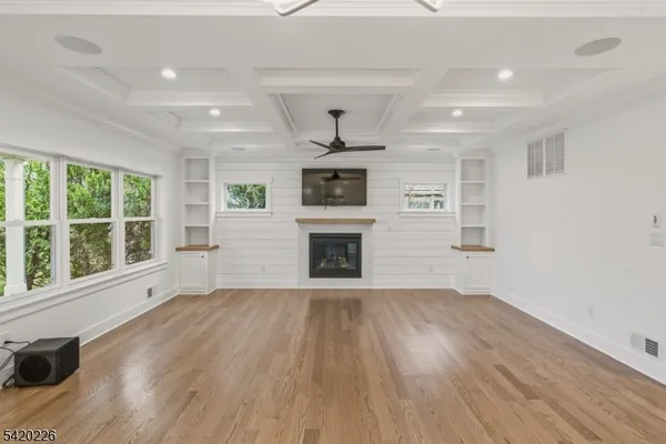 a large kitchen with a large counter top a sink stainless steel appliances and cabinets