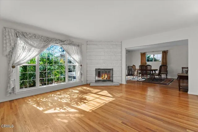 a view of a livingroom with furniture a fireplace and wooden floor